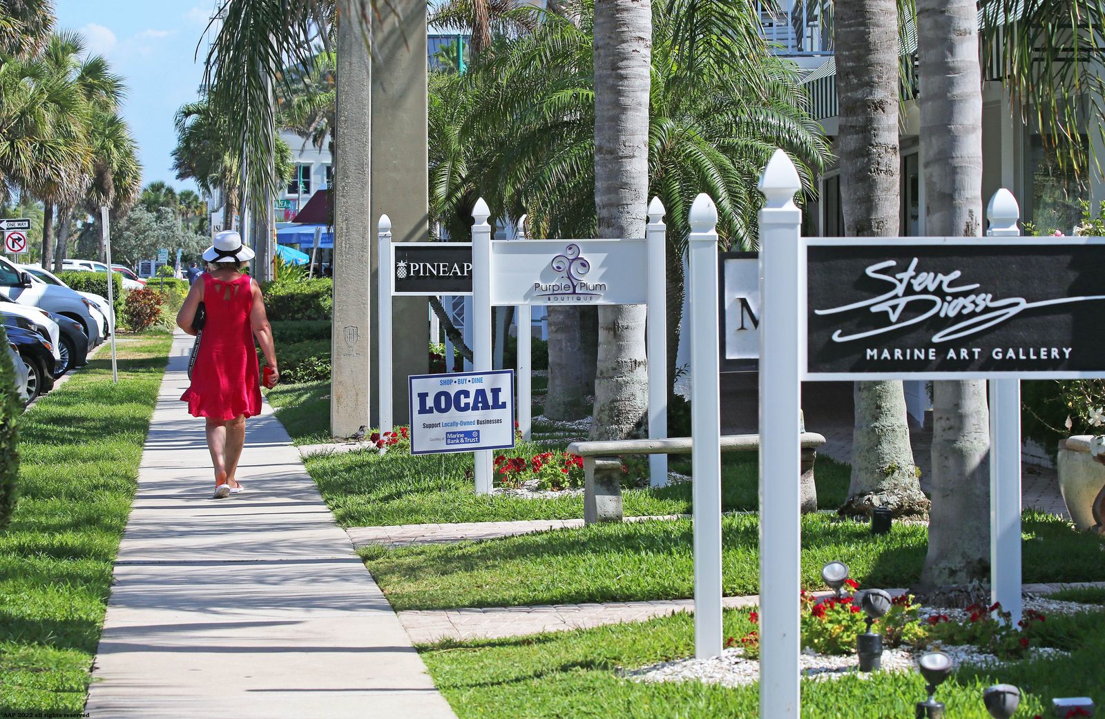 Sidewalk past shop signs, including a marine art gallery, on Ocean Drive in Vero Beach